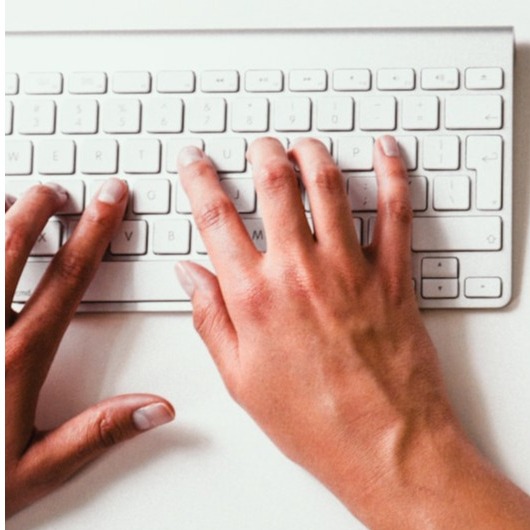 Design a welcoming image that features a friendly dental staff member answering the phone in the reception area. Showcase the bright, parrot green decor and a calming atmosphere. Include elements such as a computer and dental brochures to reflect professionalism and accessibility. The composition should capture the staff's smile and engagement. Ensure the image is high-quality and photorealistic.
